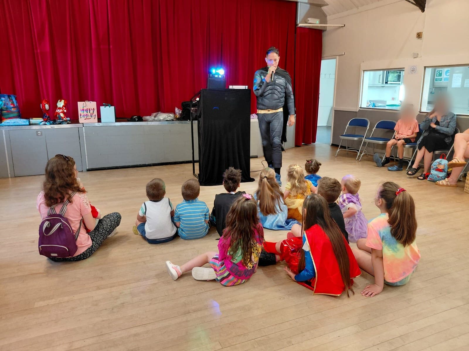 Mark running a children's party in a Surrey village hall, the whole room watching